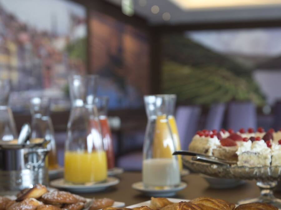 Un bufé de desayuno con bollería, fruta y bebidas.