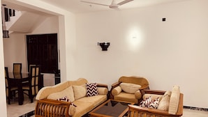 A living room with a sofa set, a coffee table, and a dining area with chairs and a table. - Ahasna Family Villa (Negombo)