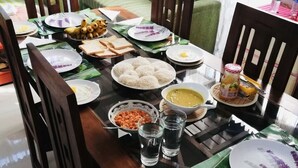 A dining table set with various dishes, including rice balls, fried eggs, and a bowl of soup. - Ahasna Family Villa (Negombo)