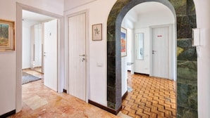 Un couloir doté d’un sol à motifs, d’une arche en pierre et d’une porte donnant sur une salle de bain.