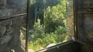 Une pièce en pierre dotée d’une grande fenêtre donnant sur un paysage montagneux.