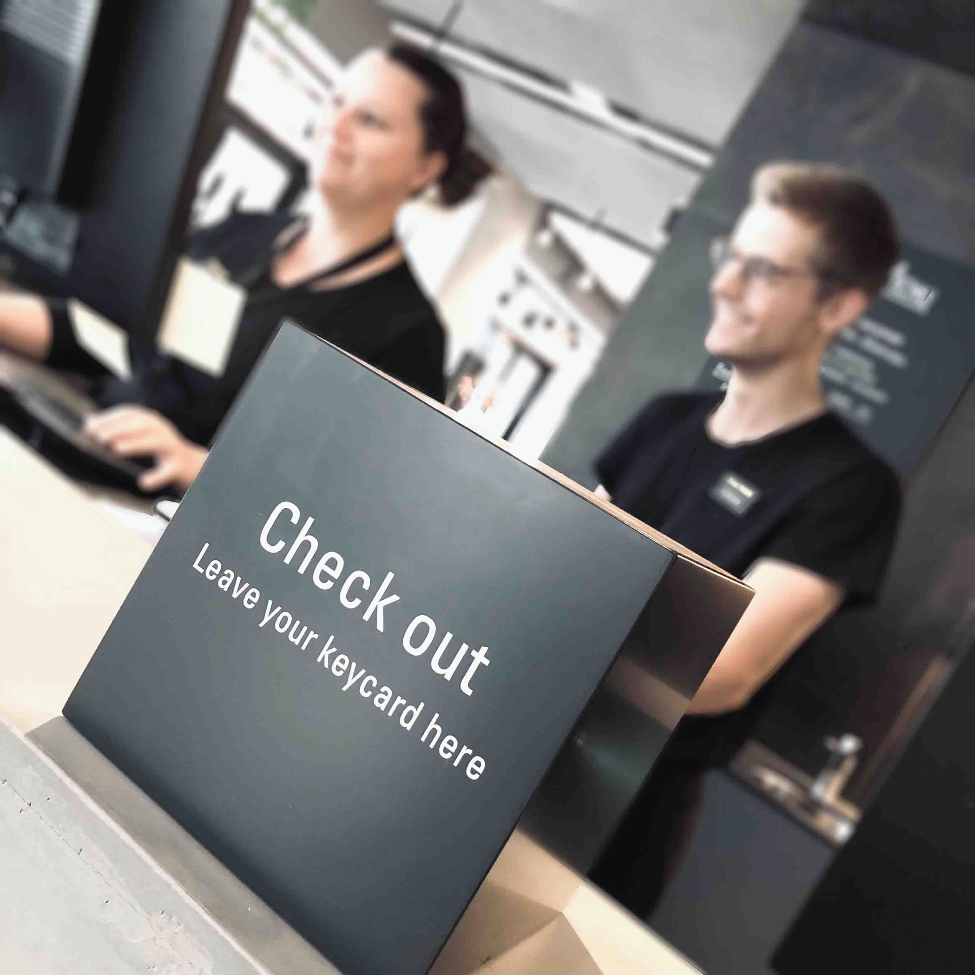 A check-out kiosk with a sign instructing to leave the keycard.