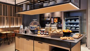 Une cuisine moderne dotée d’un îlot central, équipé de divers appareils électroménagers et de produits alimentaires.