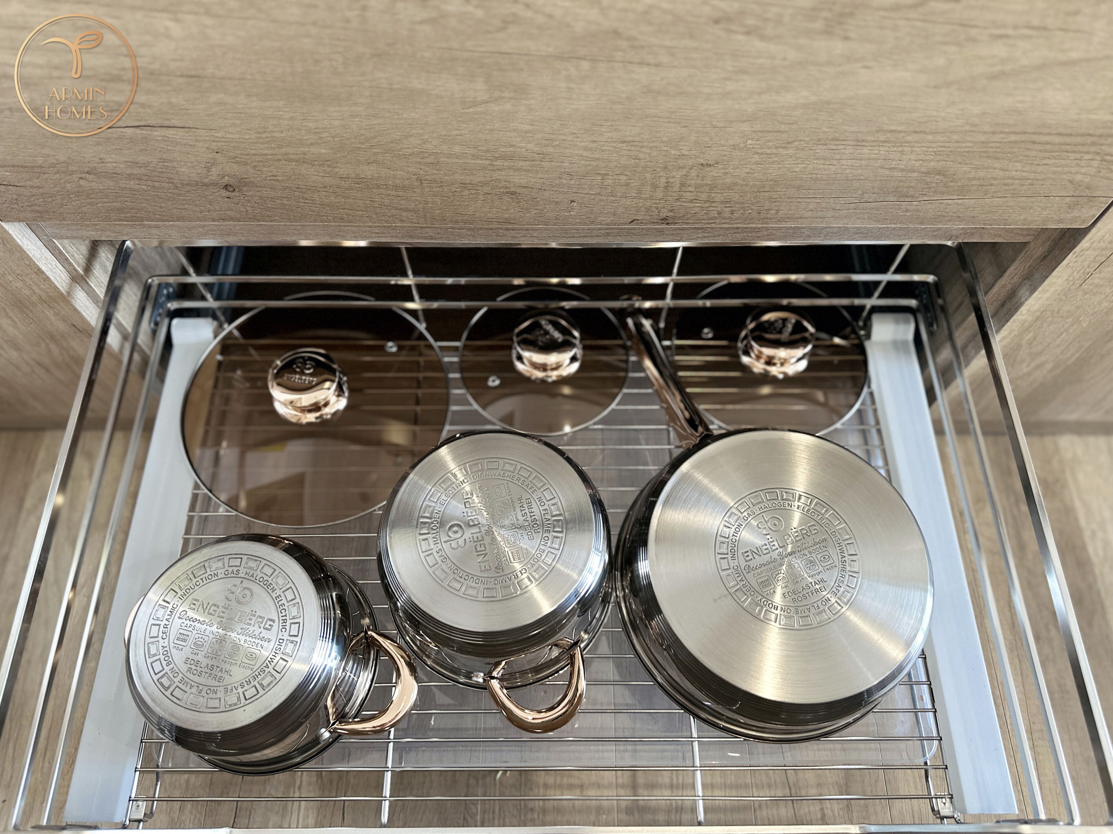 A kitchen with a stainless steel range hood, a countertop, and a sink.