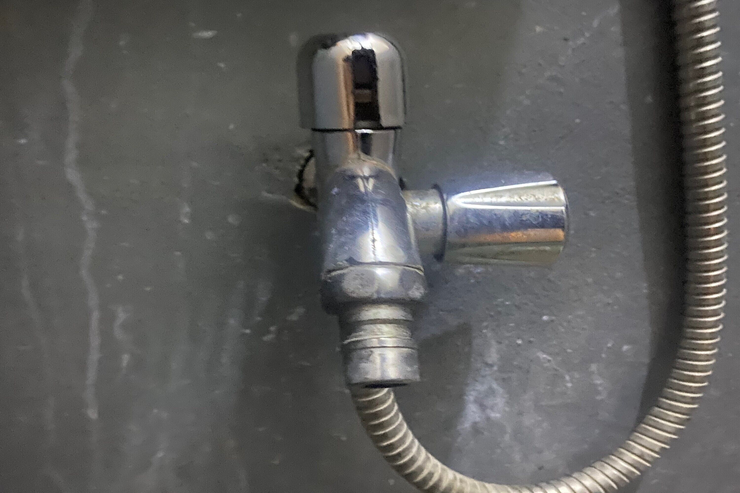 Un pommeau de douche métallique fixé au mur.