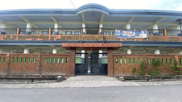 A multi-story building with a central entrance, balconies, and a signboard. - OYO Life 93401 Kos Putri Alamanda Syariah (Janapria)