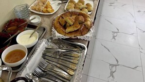 A buffet table with various food items and utensils. - hotel Shams Bukhara (Bukhara)
