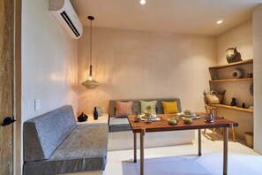 Ein modernes Wohnzimmer mit einer Couch, einem Esstisch und dekorativen Elementen.
