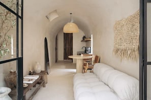 A cozy interior with a white sofa, a wooden table, and a hanging light fixture. - Casa Zebrina Romantic Design Apartment Beach Club (Tulum)