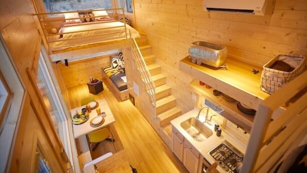 Een compacte, meerlaagse cabine met keuken, eethoek en slaapgedeelte.