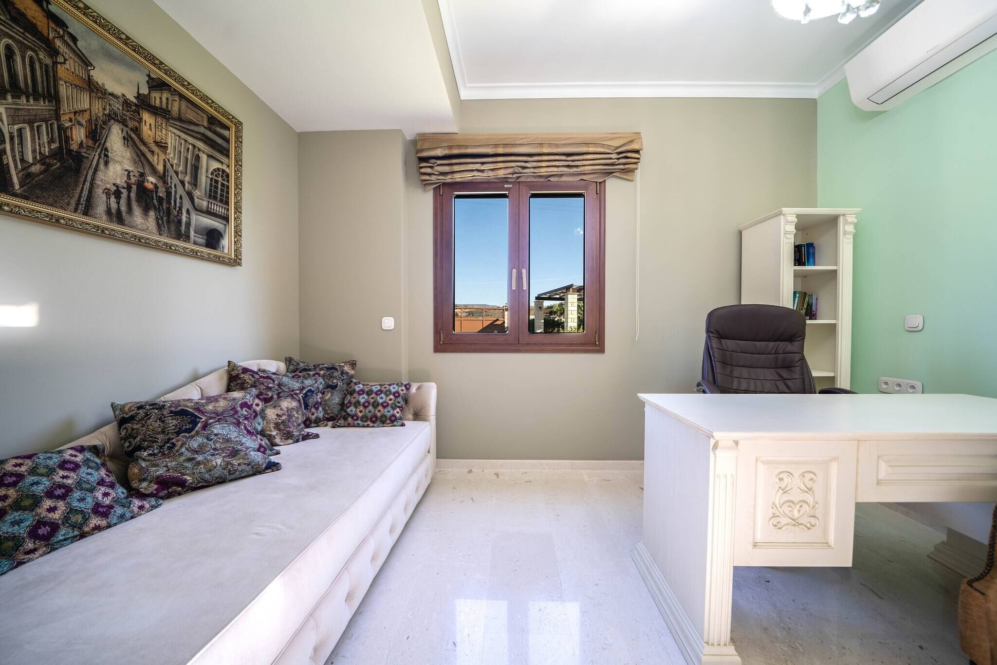 A room with a bed, a desk, a window with curtains, a bookshelf, and a painting on the wall.