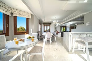 A dining area with a round table, chairs, and a view of the outdoors.