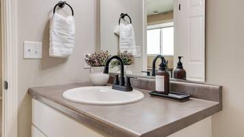 Downstairs bathroom featuring updated plumbing fixtures, modern lighting, and stylish hardware offering a fresh and functional space.