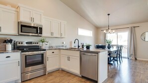A modern kitchen with white cabinets, stainless steel appliances, and a wooden floor. - Easy Access I29 & I94 - Family Friendly - Spacious (Fargo)