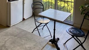 Eine kompakte Küche mit Essbereich, einem Kühlschrank, einer Spüle und einem Fenster mit Blick auf Grünflächen.