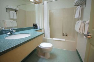 Un baño con lavamanos, inodoro y ducha.