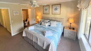 A bedroom with a bed, two bedside tables, a ceiling fan, and two wall-mounted lamps. - Awesome Hilton Head Coligny Beach townhome! (Hilton Head Island)