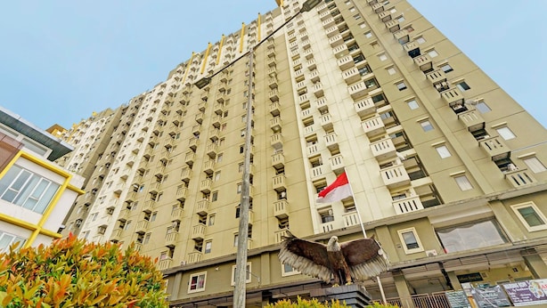 Un edificio alto con múltiples balcones y una bandera.