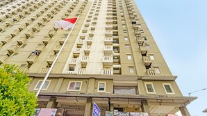 Un edificio alto con varios balcones y una bandera.