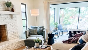 A living room with a fireplace, a sofa, a coffee table, and a view of the outdoors. - A charming canal front home...close to the beach, and perfect for boat lovers! (Bonita Springs)