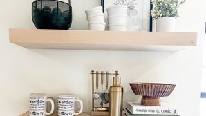 A kitchen with two wooden shelves, a coffee maker, a kettle, and a basket. - A charming canal front home...close to the beach, and perfect for boat lovers! (Bonita Springs)