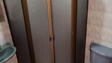 A bathroom with a shower enclosure, toilet, and sink.