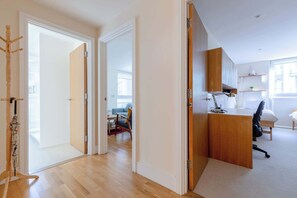 2 habitaciones, escritorio y tabla de planchar con plancha