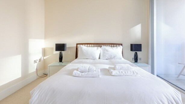 Une chambre d’hôtel avec un grand lit, deux tables de chevet et une vue sur l’extérieur.