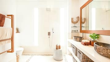 Une salle de bain moderne équipée d’une douche, de toilettes et d’un meuble-lavabo avec un grand miroir.