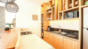 Une cuisine moderne avec des meubles en bois, un évier en acier inoxydable et un four à micro-ondes encastré.