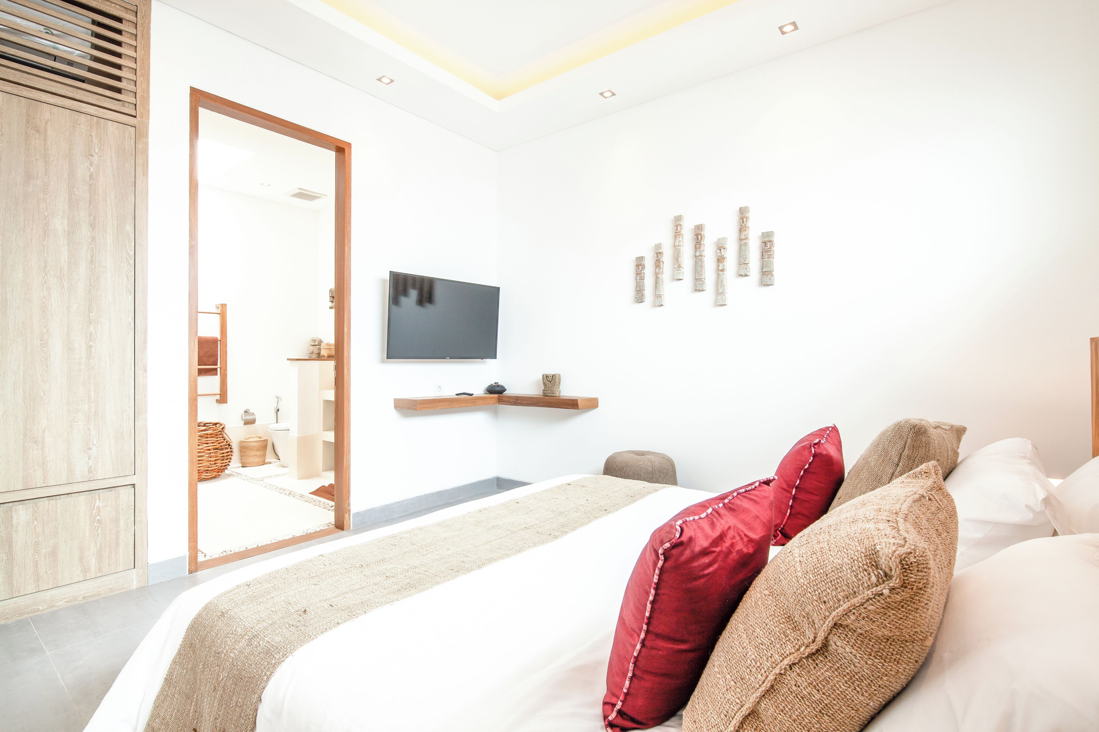 Une chambre moderne avec un grand lit, une télévision et un décor minimaliste.