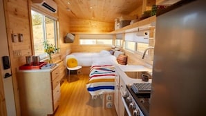 Un piccolo alloggio con angolo cottura, un letto e un bagno.