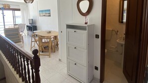A spacious living area with a dining table and chairs, a staircase with a wooden railing, and a white cabinet with drawers. - Baia - With a bay View (Alcobaça)