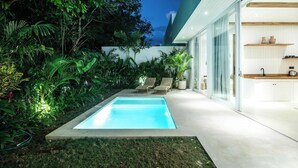 Une maison moderne dotée d’une piscine, d’une végétation luxuriante et d’un intérieur minimaliste.