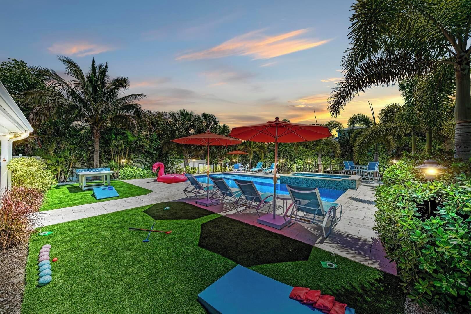 A backyard with a swimming pool, lounge chairs, and a flamingo float.
