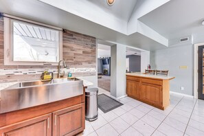 A modern kitchen with a stainless steel sink, wooden cabinets, and a window with blinds. - Cozy Wisconsin Escape w/ Deck, Grill & Fire Pit! (Pleasant Prairie)