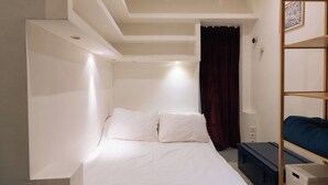 Une chambre à coucher comprenant un lit, une armoire et une étagère.