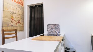Una habitación con un mapa de Francia en la pared, una silla de madera, una mesa y un objeto decorativo sobre la mesa.