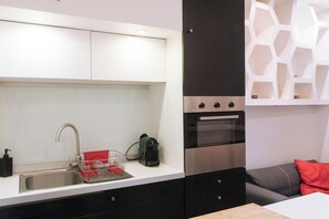 A modern kitchen with a stainless steel sink, a coffee machine, and a built-in oven. - Perfect Studio Getaway for Lovers & Solo Explorers (Paris)