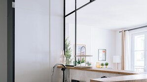 Een moderne keuken met een zwart aanrecht, een ingebouwde spoelbak en een raam boven de spoelbak.