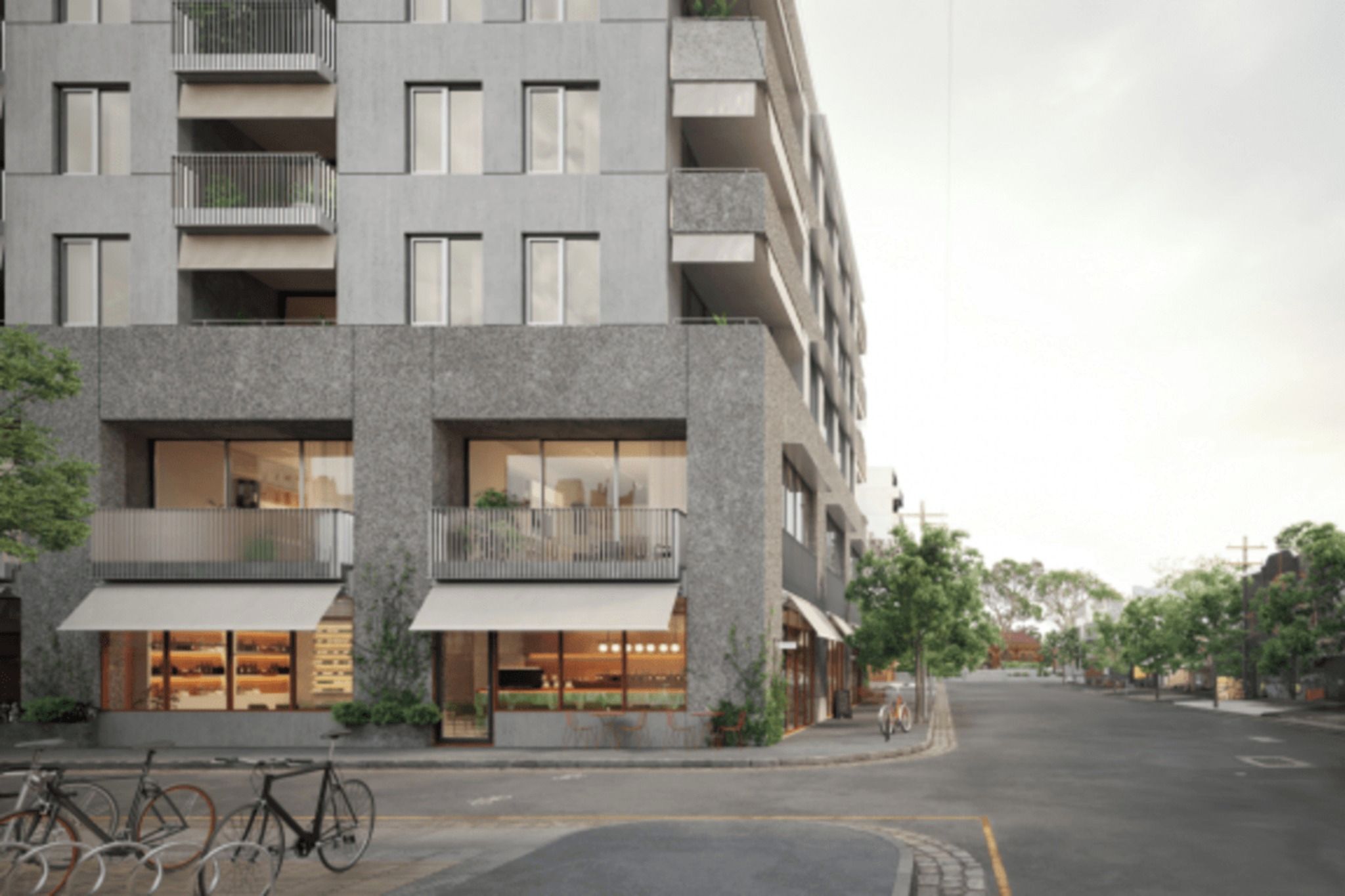 Un edificio moderno de varios pisos con balcones, ventanas amplias y una bicicleta estacionada adelante.