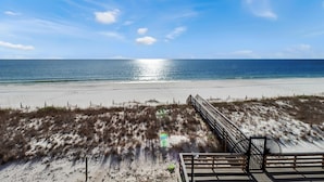A beach view with a wooden boardwalk, sandy dunes, and the ocean. - The Vue 2C (Port St. Joe)