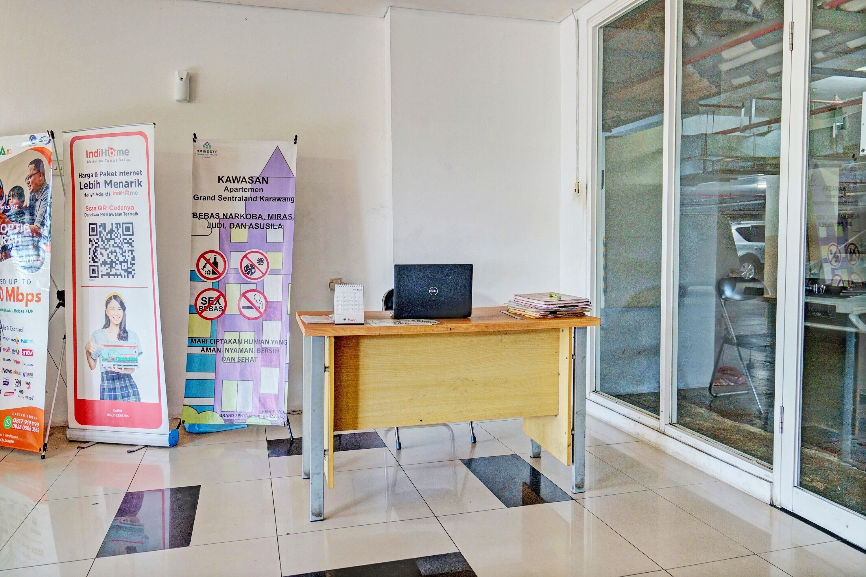A clean office space with a desk, a laptop, and informational posters on the wall.