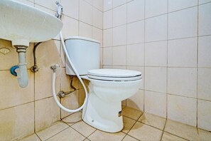 Bathroom features a wall-mounted sink and toilet with a tiled surround.