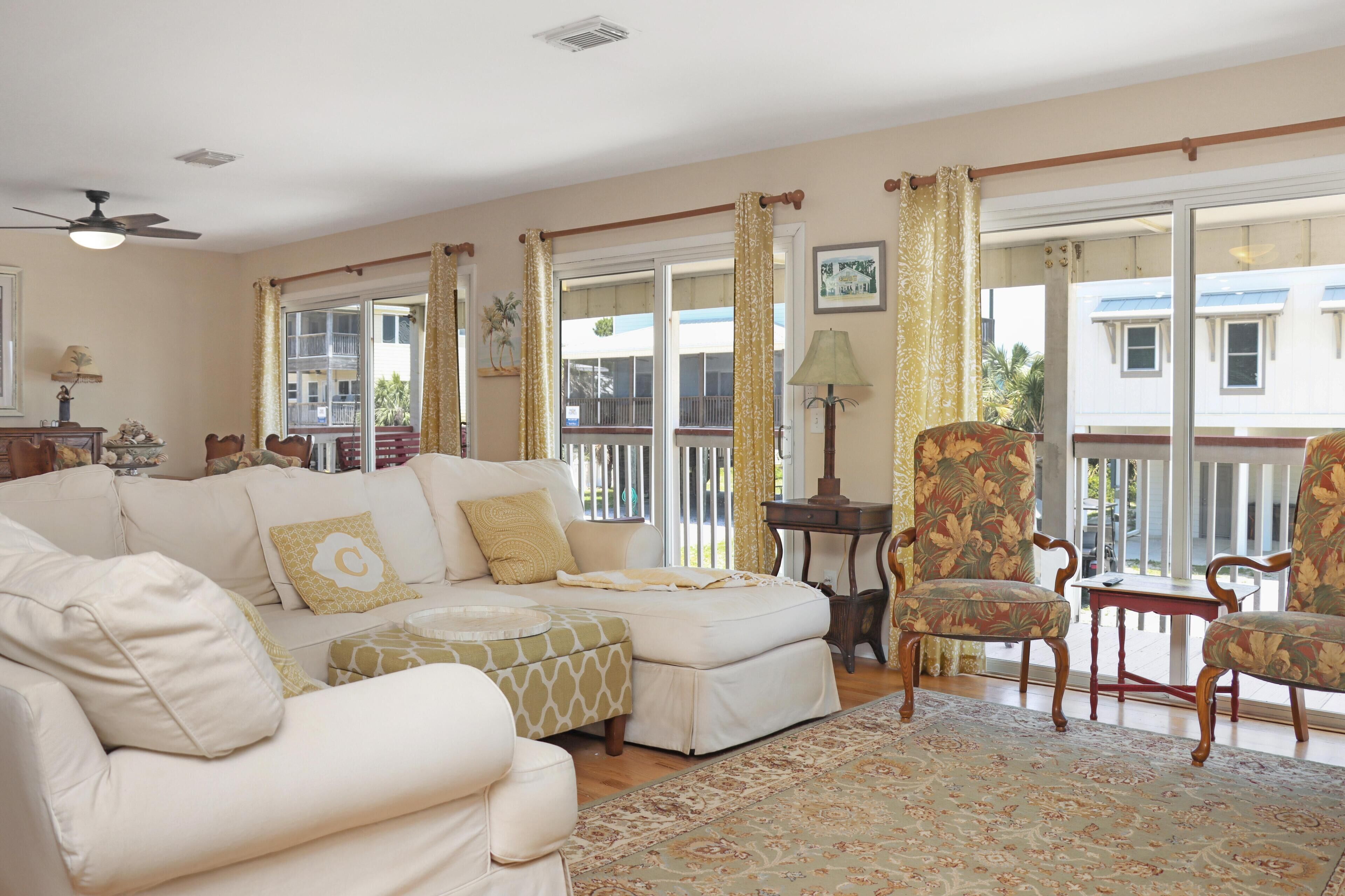 A living room with a sofa, armchairs, a small table, and a floor lamp.