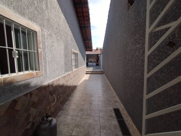 Staircase and corridor leading to an open area with a tiled roof.