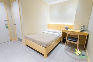 Een hotelkamer met een bed, een bureau en een stoel.