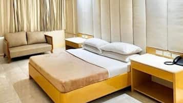 Une chambre à coucher moderne avec un lit, des tables de chevet, un canapé et une tête de lit.