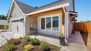 A single-story house with a garage, a covered porch, and a brick exterior. - Holly Grove Cottage W/ Hot Tub (Vancouver)