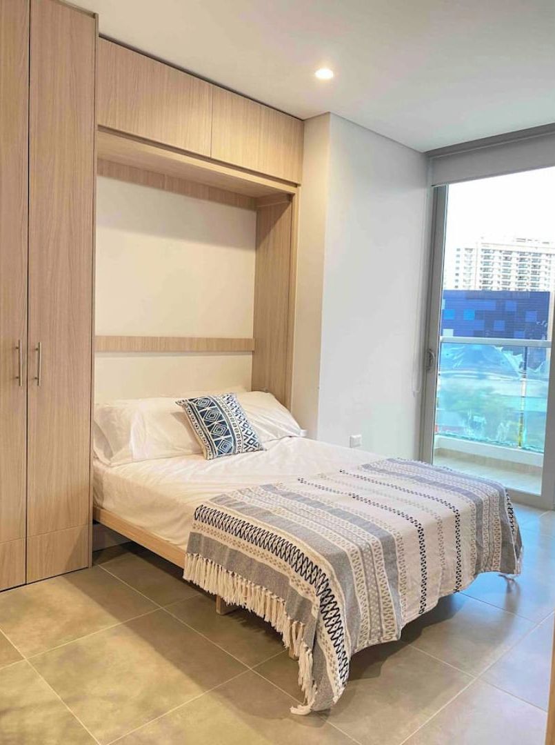 Una camera da letto con un letto, un armadio e una grande finestra.